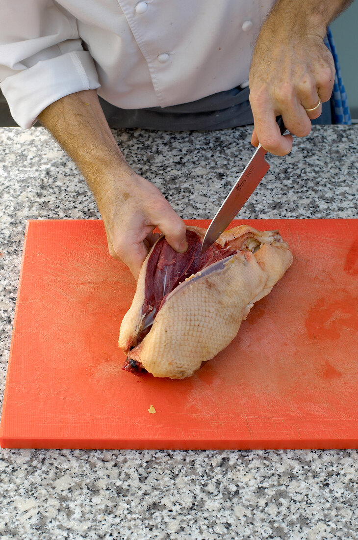 Cutting duck breast on cutting board