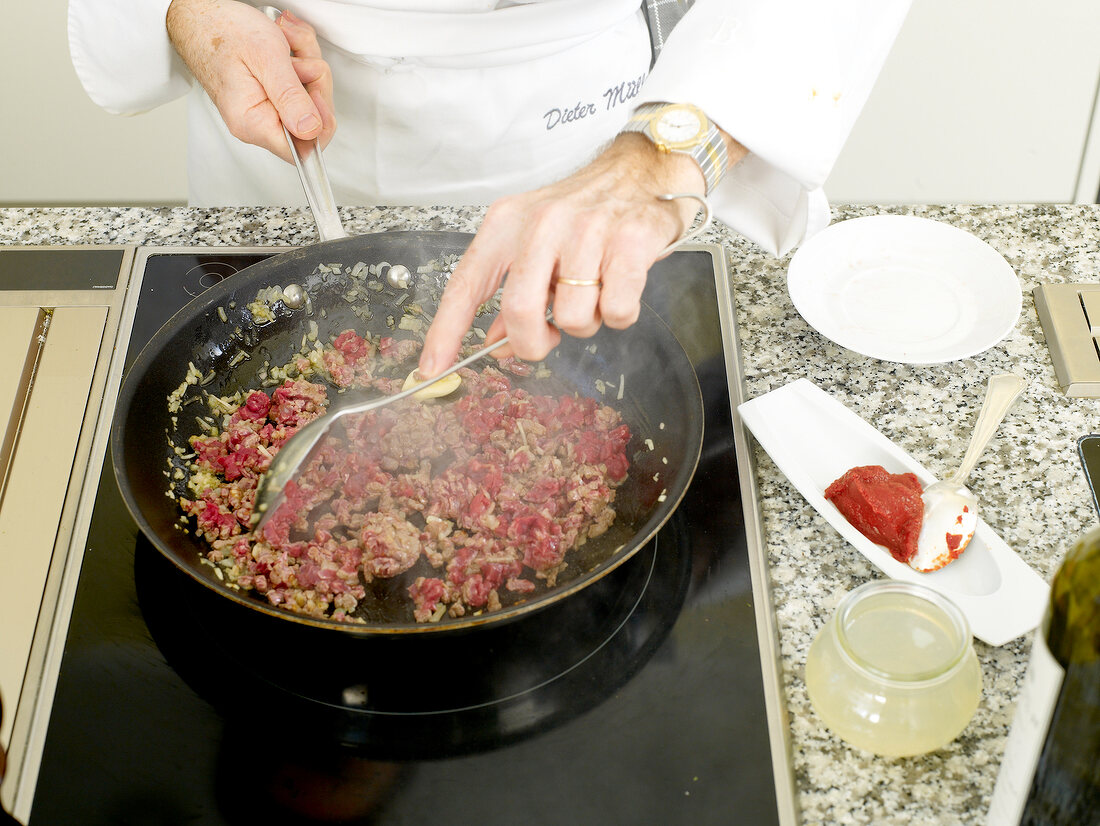 Mixing the ingredients of beef sauce in frying pan