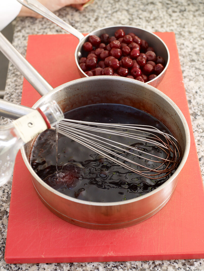 Adding wine vinegar to mixture in saucepan with whisk