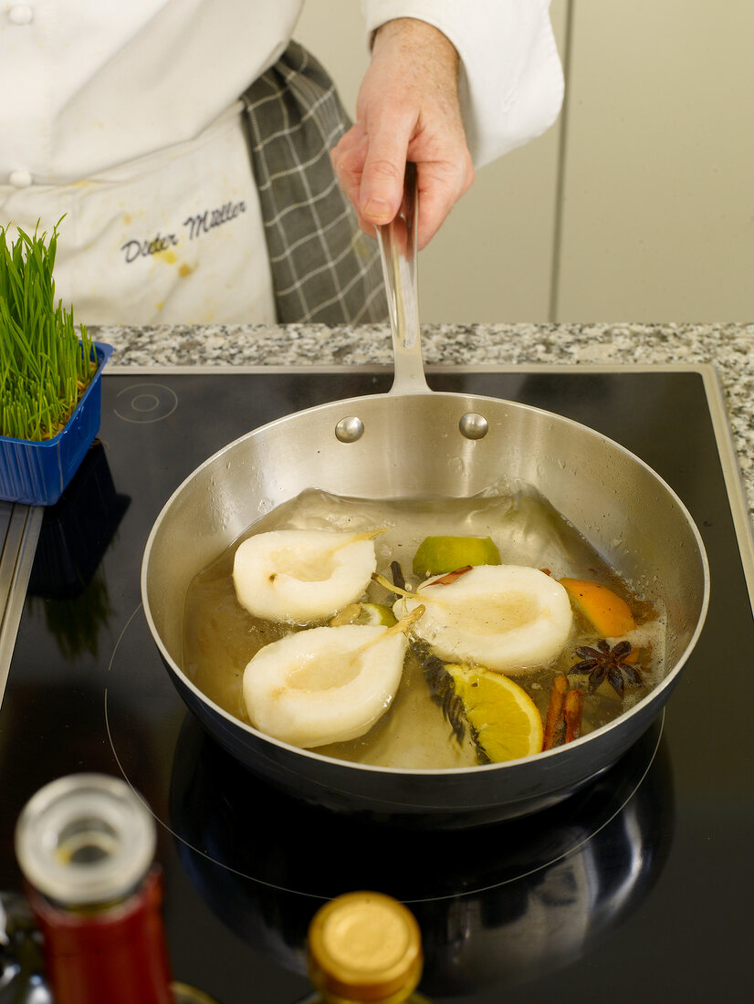 Boiling pears with spices in saucepan
