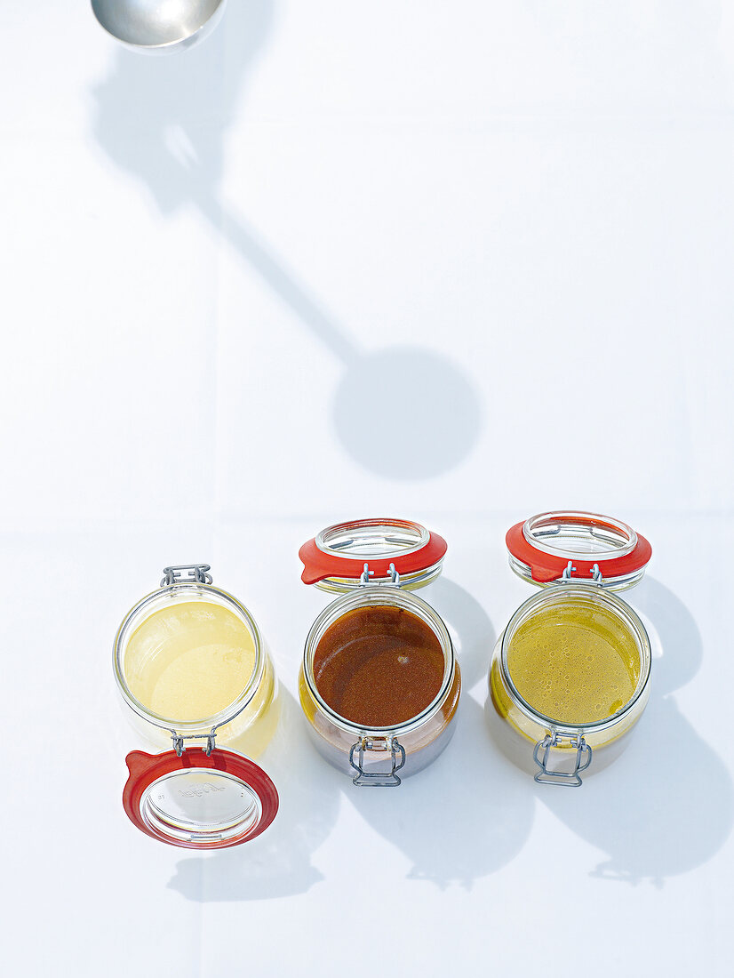 Three jars with different liquids on white background