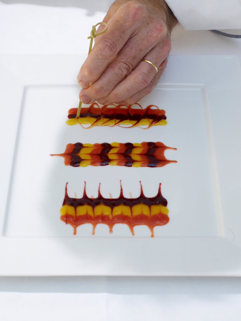 Plate being decorated with different type of fruit sauces