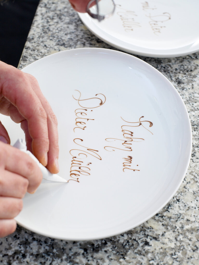 Plate being decorated with chocolate sauce