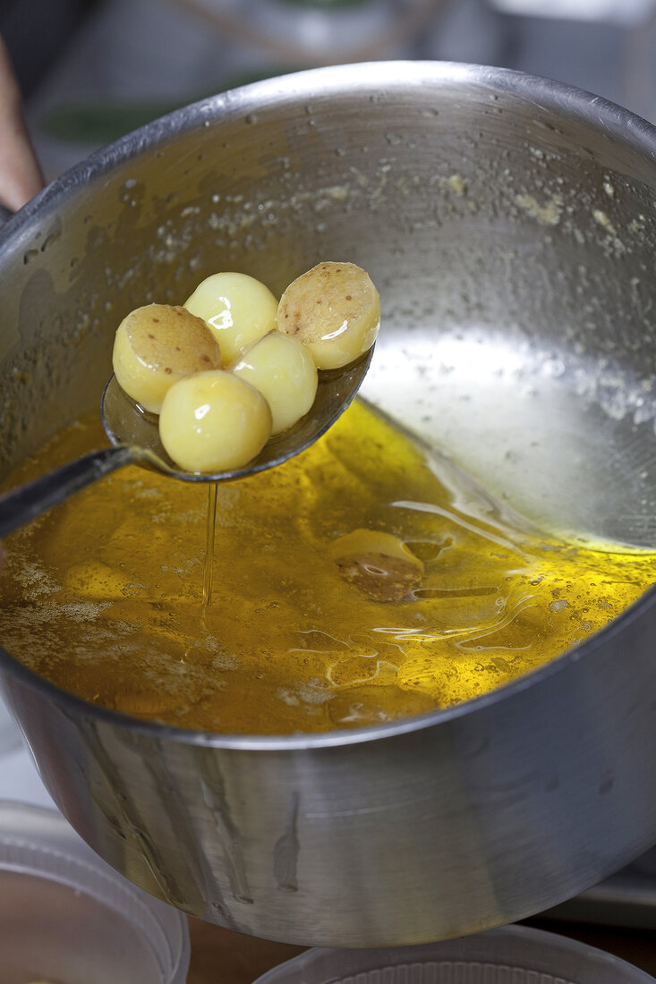 Close-up of potato balls being taken out from pot