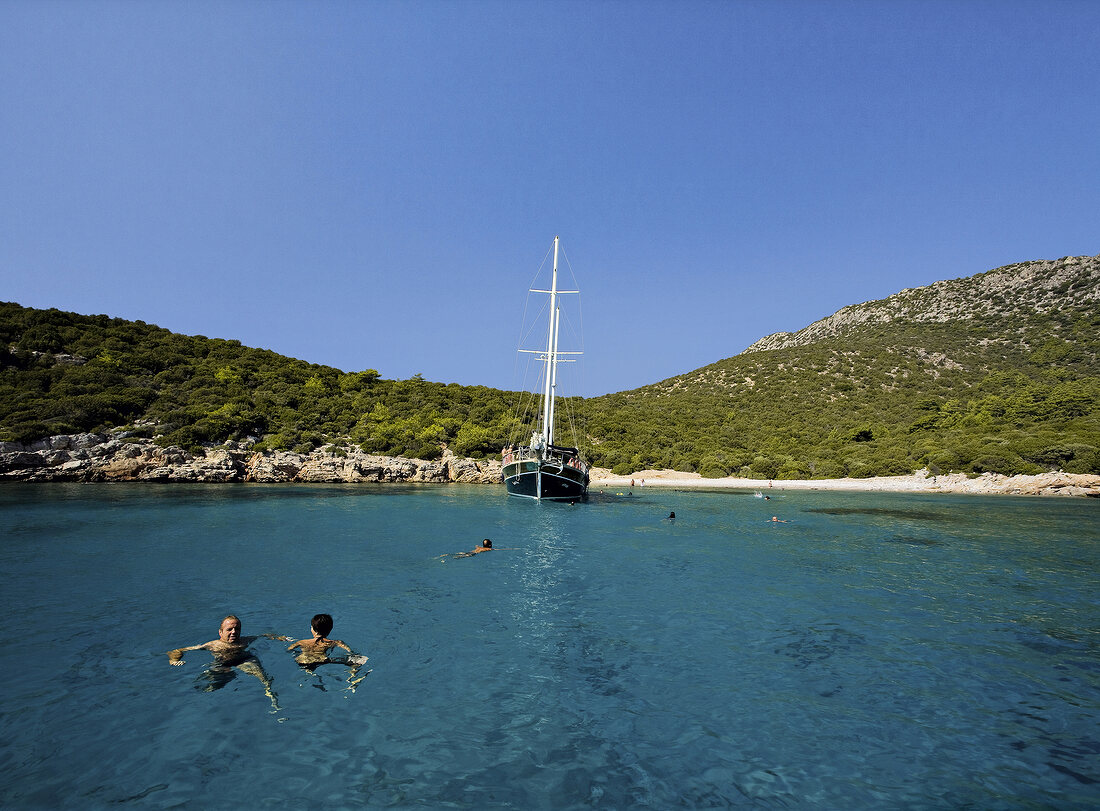 People swimming in sea in front of sailboat in Bodrum, Mugla Province, Turkey