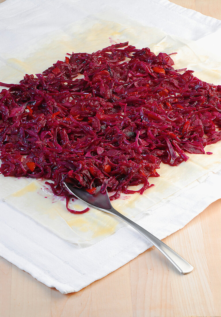 Close-up of red cabbage being rolled with phyllo sheet