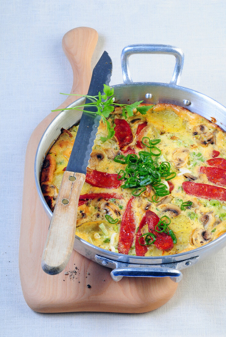Tortilla with potatoes and mushrooms in steel casserole