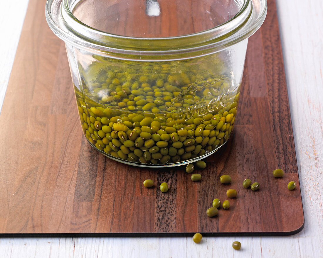 Moong bean soaked in water in glass jar, step 1