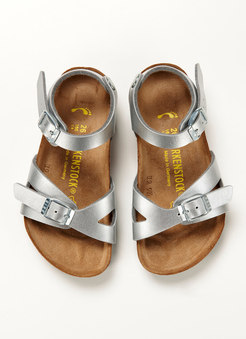 Close-up of silver sandal for children on white background