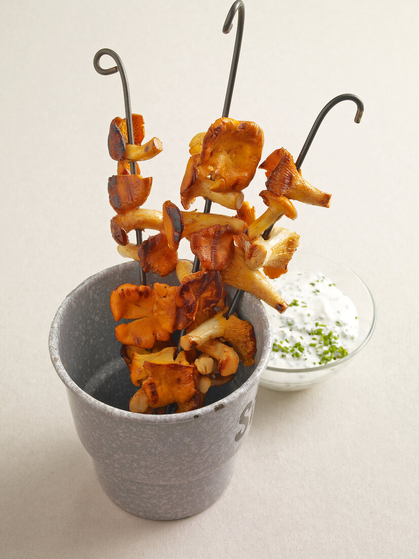 Chive cream in bowl and chanterelle skewers in glass