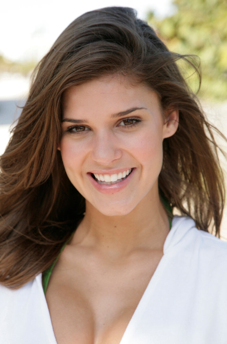 Portrait of beautiful dark haired woman wearing white zipper jacket smiling, close-up