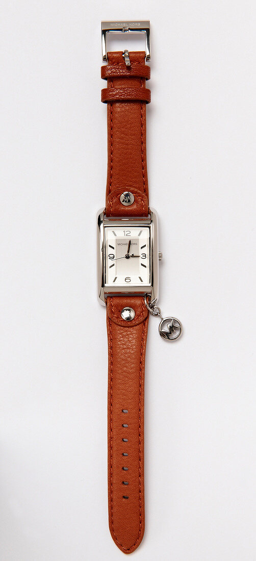 Close-up of wrist watch with leather strap on white background