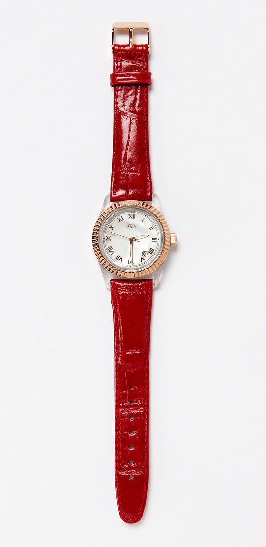 Close-up of wrist watch with red leather belt on white background