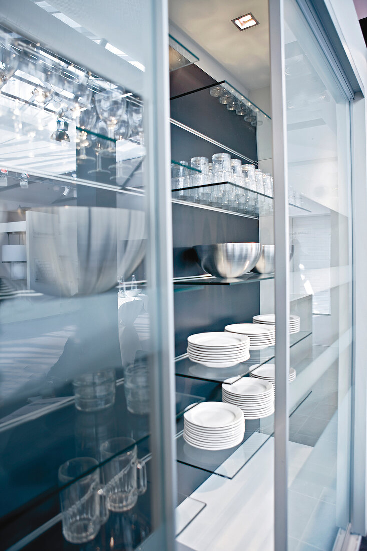Close-up of display case with stack of plates, glasses and bowl