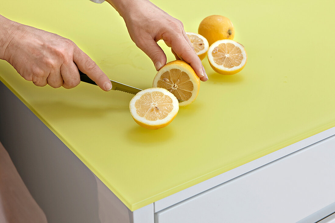 Zitronen werden auf einer gelbgrünen Arbeitsplatte geschnitten