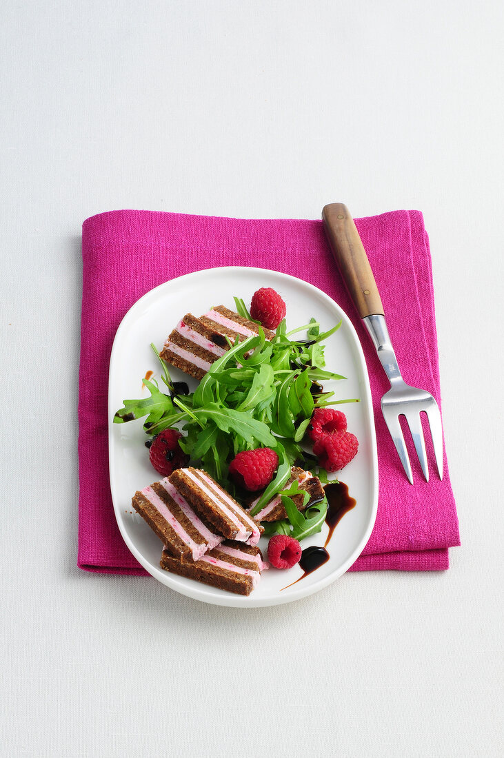 Pumpernickel salad with raspberries and rocket leaves on plate