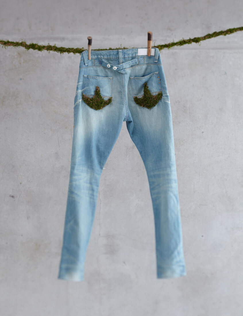 Öko-Denim: Jeanshose auf der Leine, mit Moos verziert