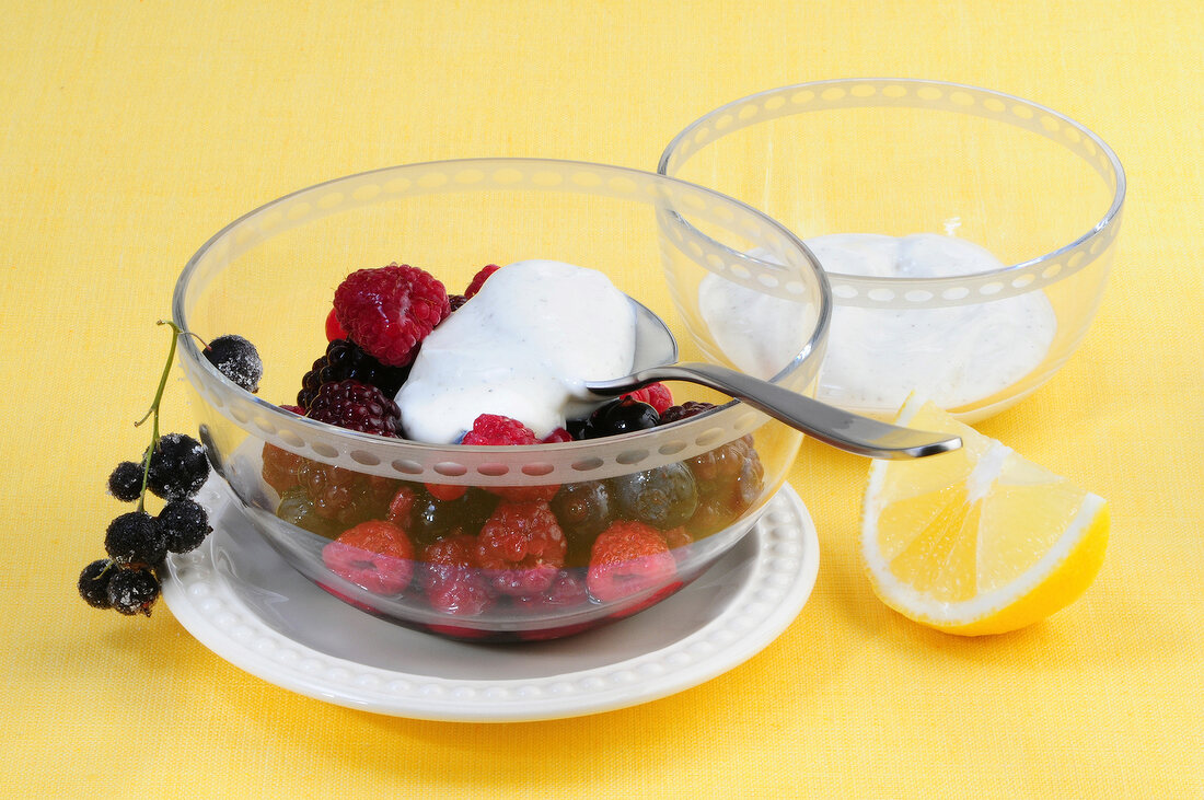 Wild berry salad with goat cheese cream in glass bowl
