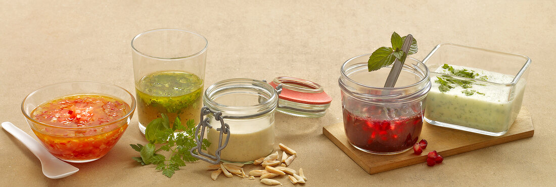 Five different types of salads in glass jars and bowls