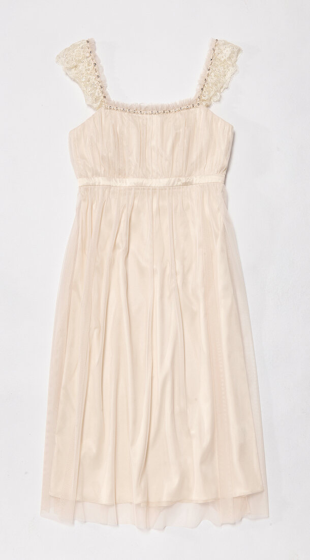 Cream coloured chiffon dress with rhinestones and pearls on white background