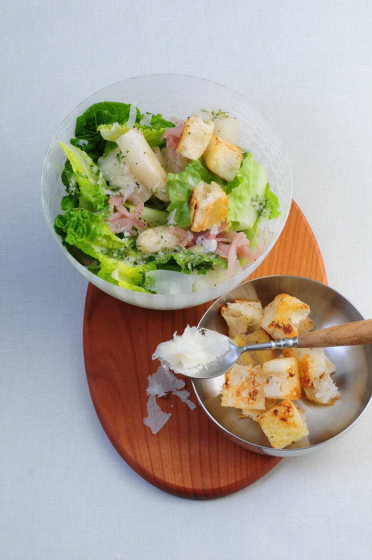 Romaine lettuce with ham and asparagus in bowl with croutons