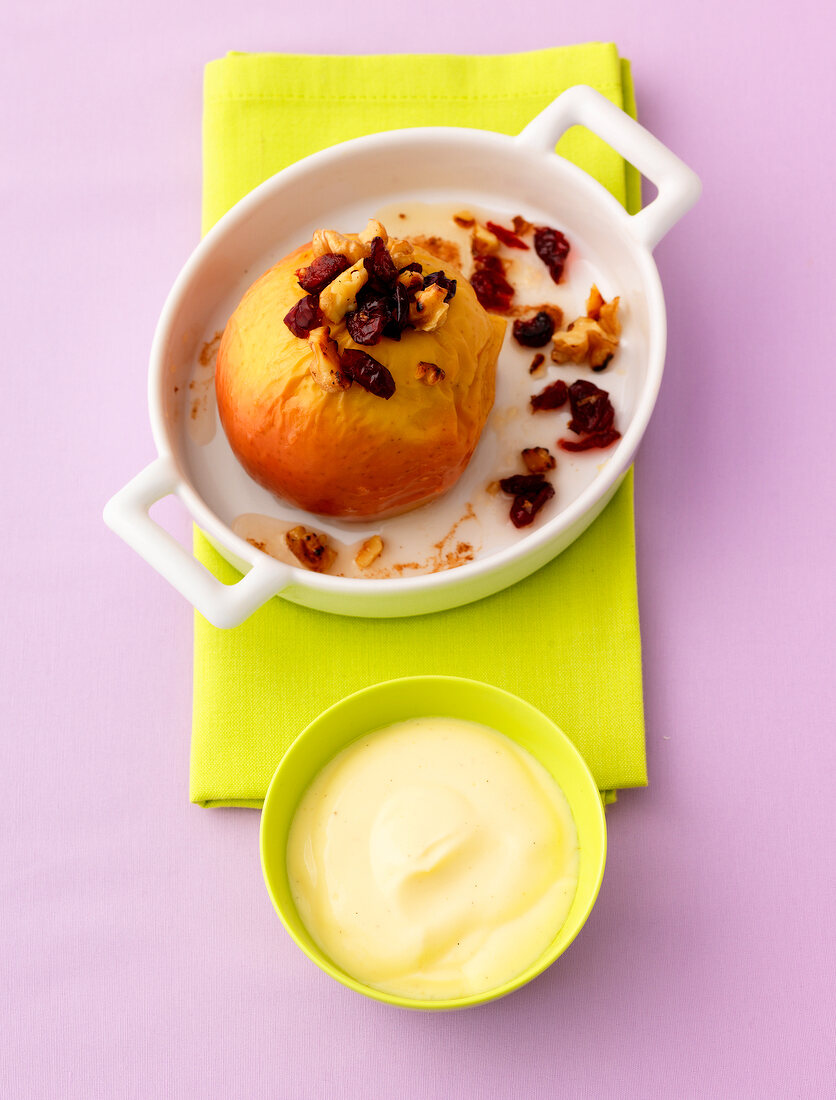 Baked apple with cranberry and vanilla yogurt in bowl