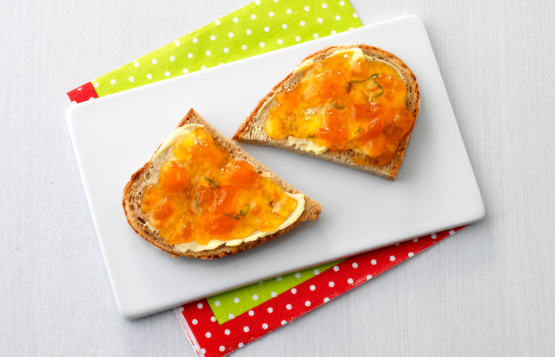 Two slices of bread coated with marmalade on plate