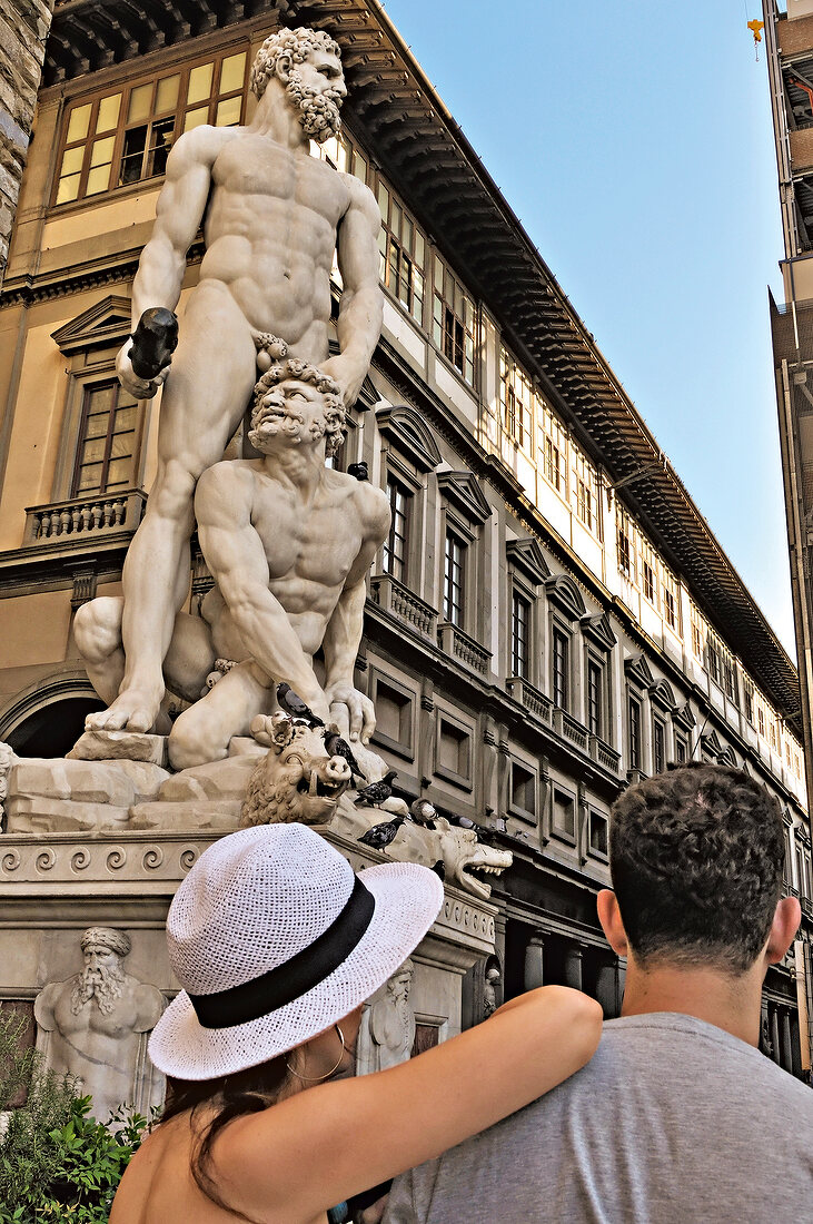 Tourist standing in front of Hercules and Cacus sculpture in Florence, Italy