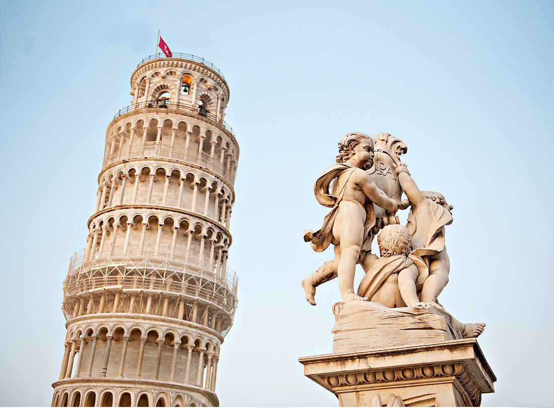 View of Leaning Tower of Pisa with statue in foreground, Italy