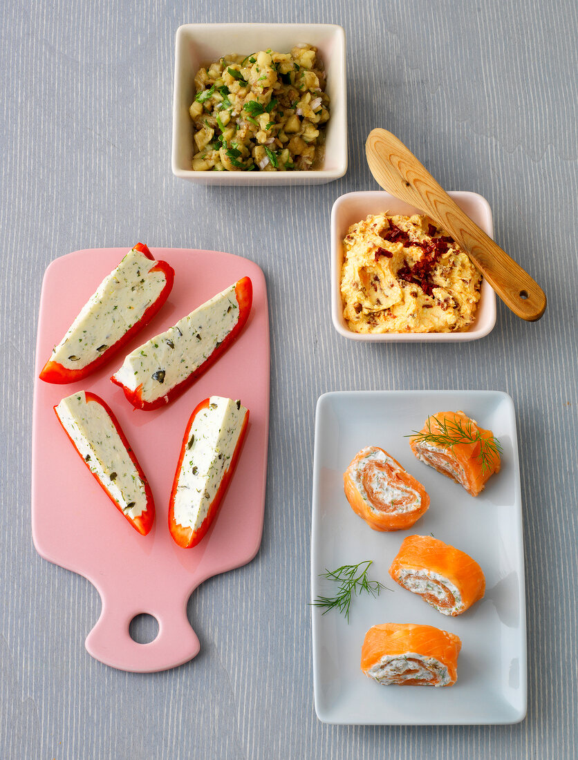 Different appetizers of bread in bowl, plate and serving board