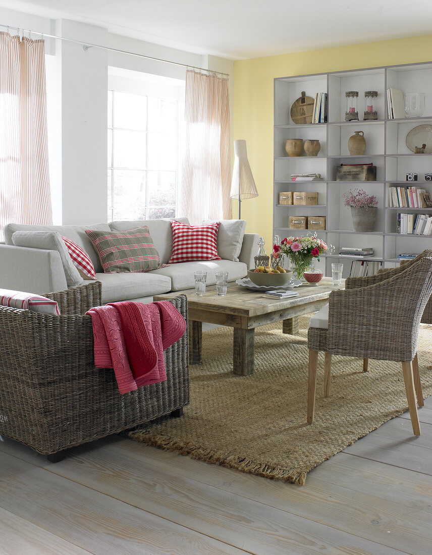 Living room with wicker furniture , book shelf and curtains