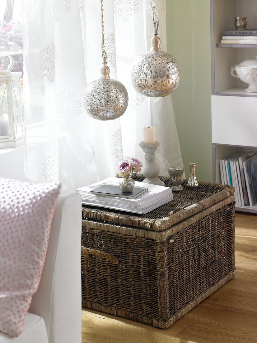 Living room with wicker box and silver pendant light fittings made of sheet metal