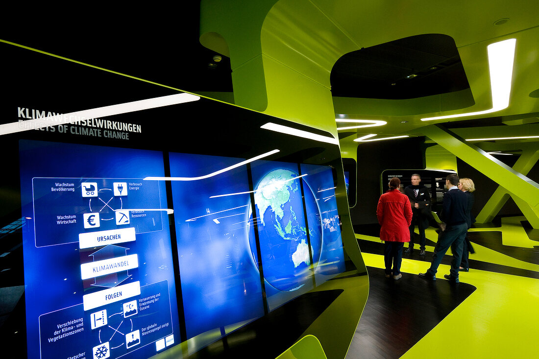 Visitors looking at display board in pavilion Level Green, Autostadt, Wolfsburg, Germany