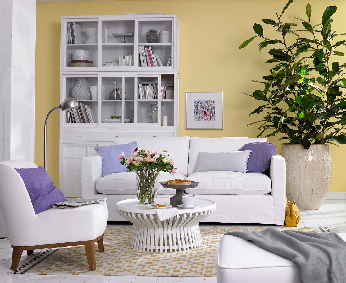 Living room with upholstered furniture, china cabinet and green plants