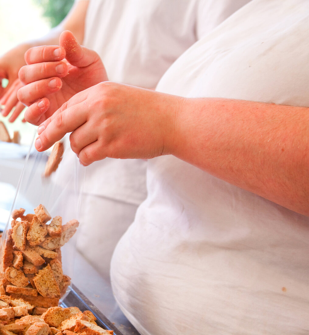 Close-up of man's hands packing biscuits