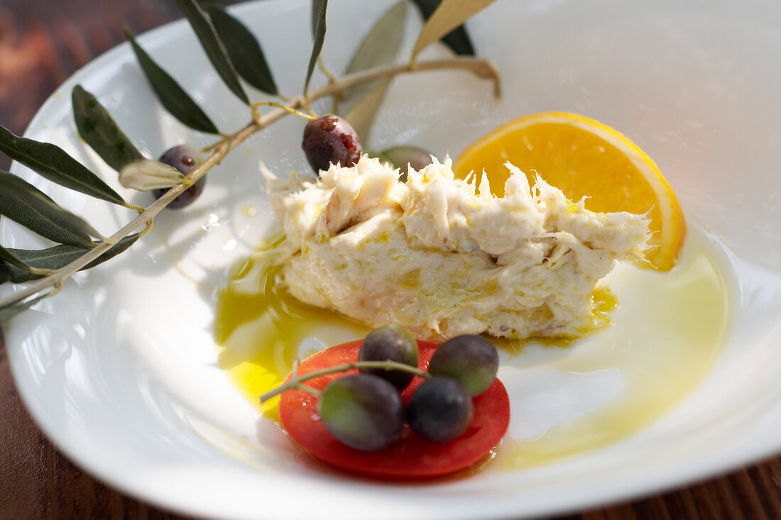 Close-up of steamed fish fillet with olive oil on plate