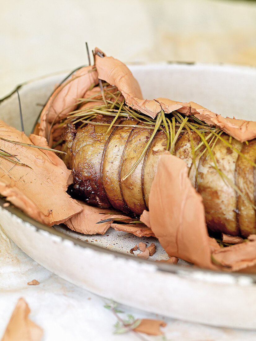 Saddle of lamb in pastry with pine needle in serving dish