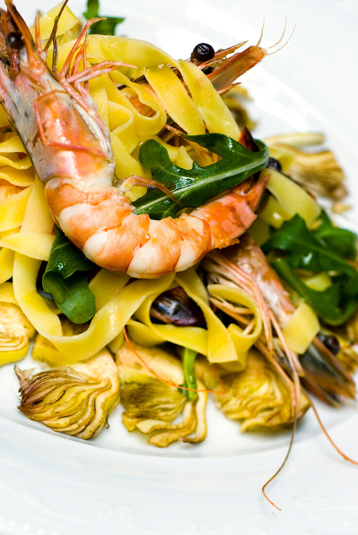 Close-up of tagliatelle pasta with artichokes and shrimp on plate