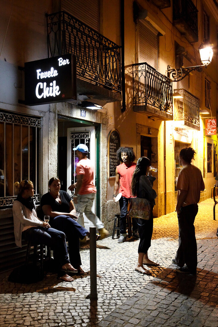 People in front of Bar Favela at night, Bairro Alto, Lisbon, Portugal