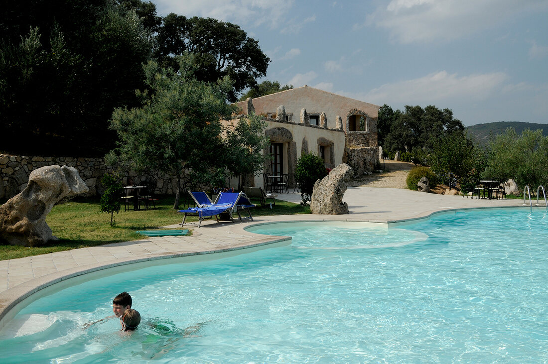 People enjoying in pool of hotel Funtana Abbas in Lura, Sardinia island, Italy