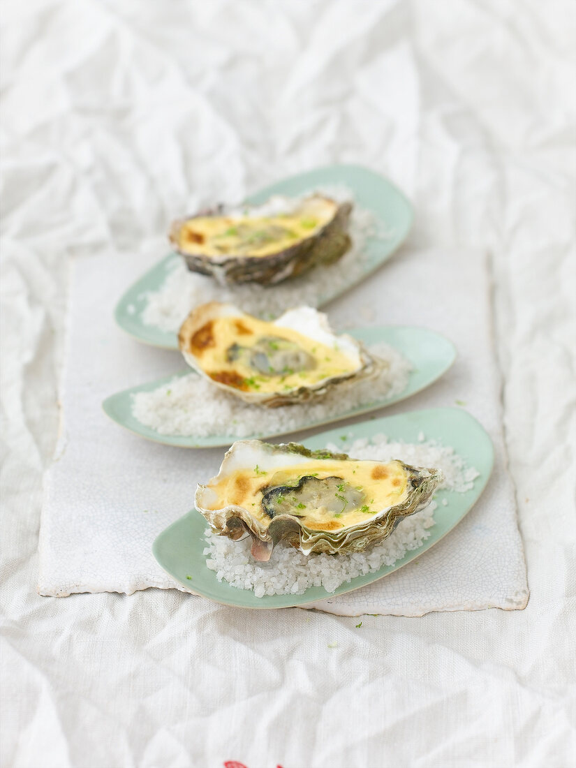 Three gratin of oysters on white background