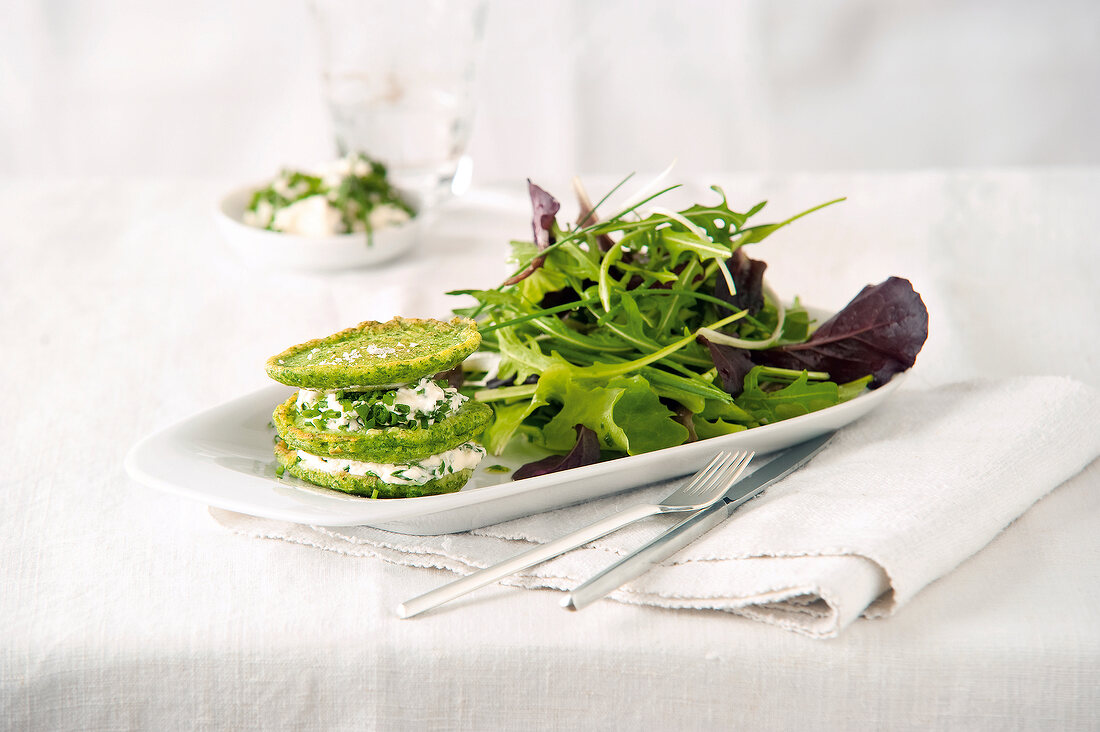 Green pancake with chive quark salad on tray