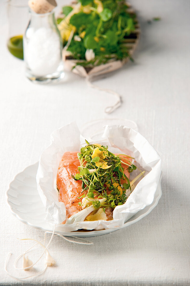 Boneless salmon garnished with parchment herb on plate