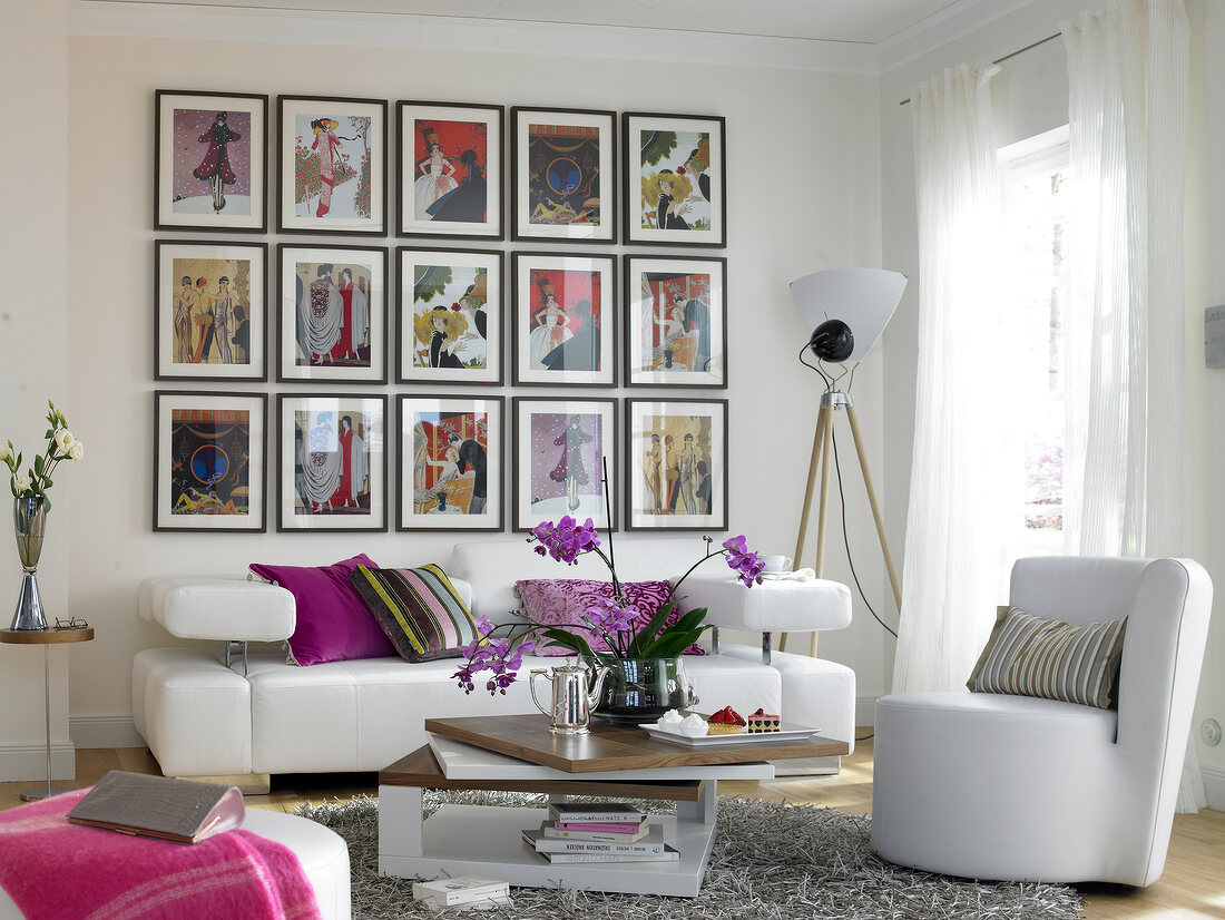 Living room with white sofa and gallery with art deco motifs on wall