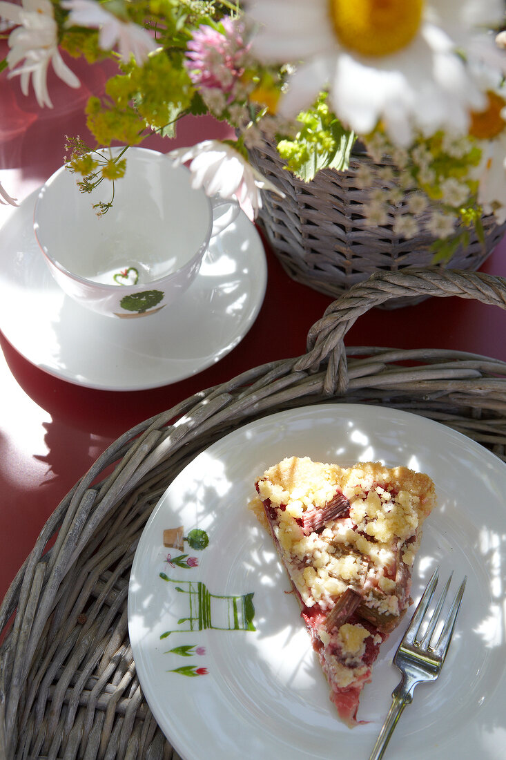 Ein Stück Rhabarberkuchen, Porzellantasse, Blumen