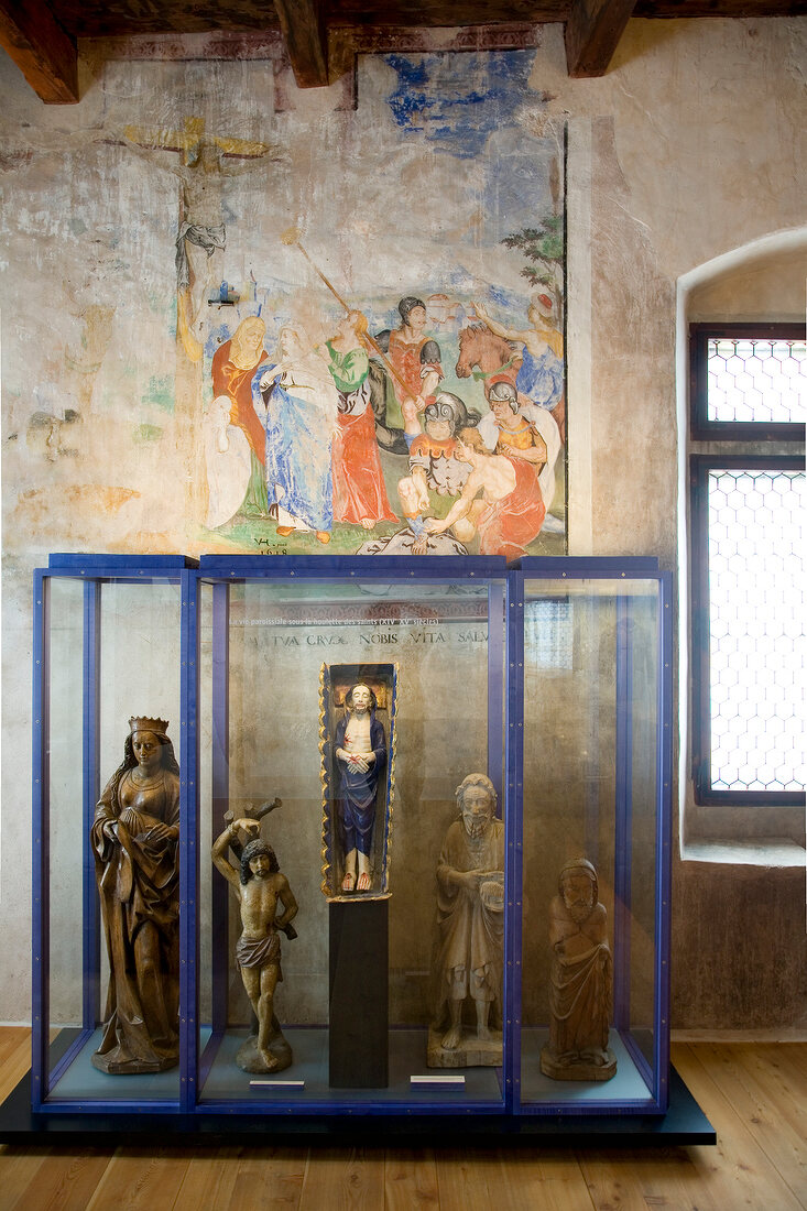 Wooden sculptures in front of fresco painting at Castle Valeria, Sion, Switzerland