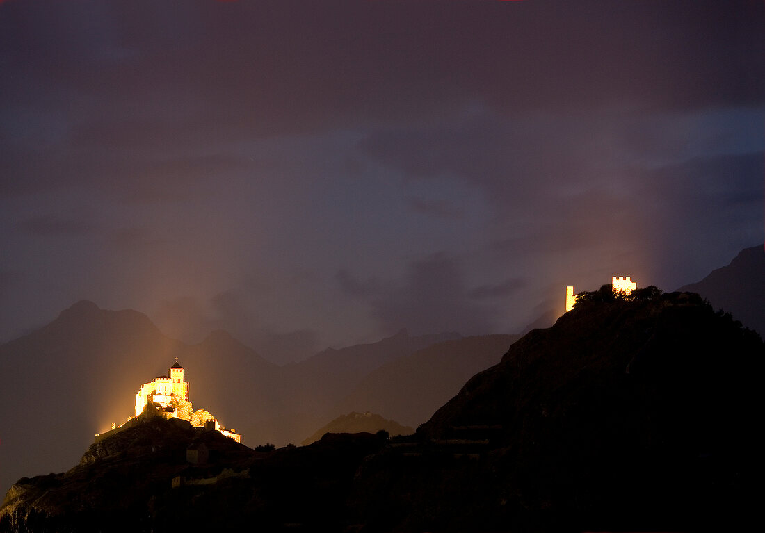 Wallis, Zwei Burgen leuchten nachts über Sion