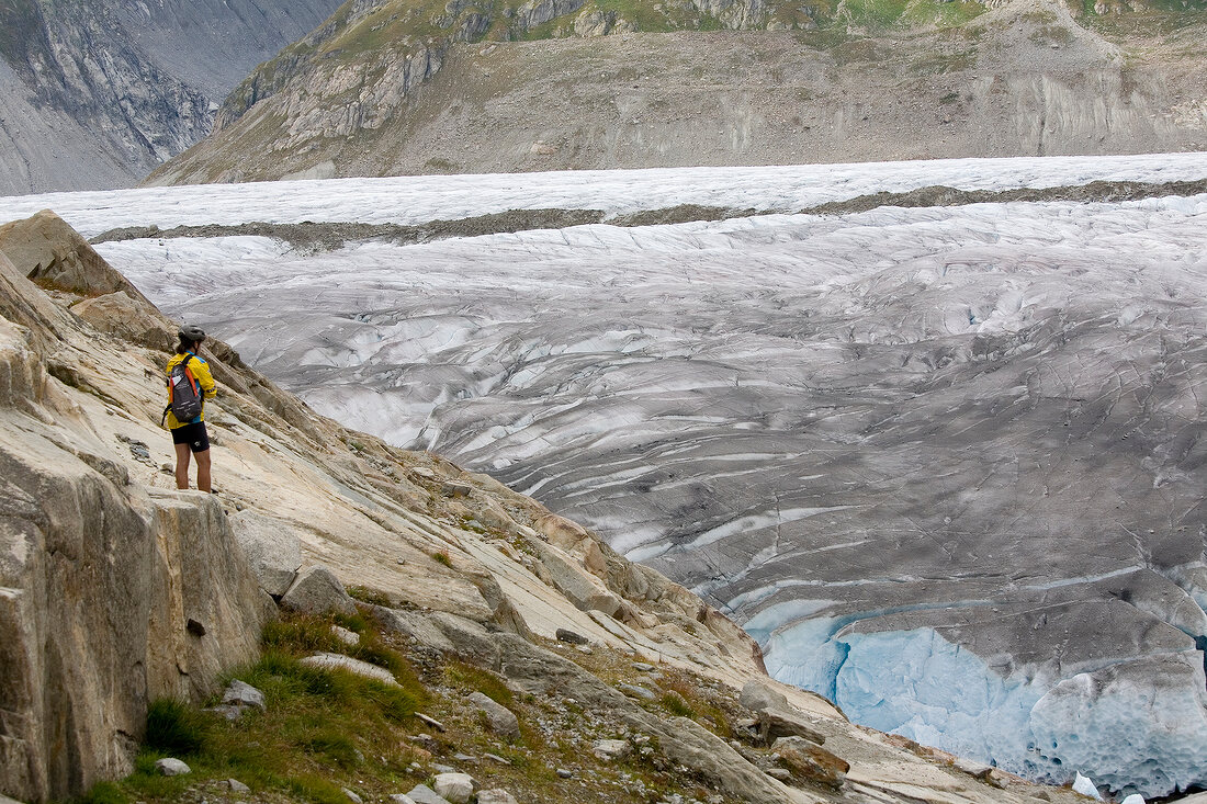 Hiker in front of ice wall in Aletsch Glacier, Marjelesee, Valais, Switzerland