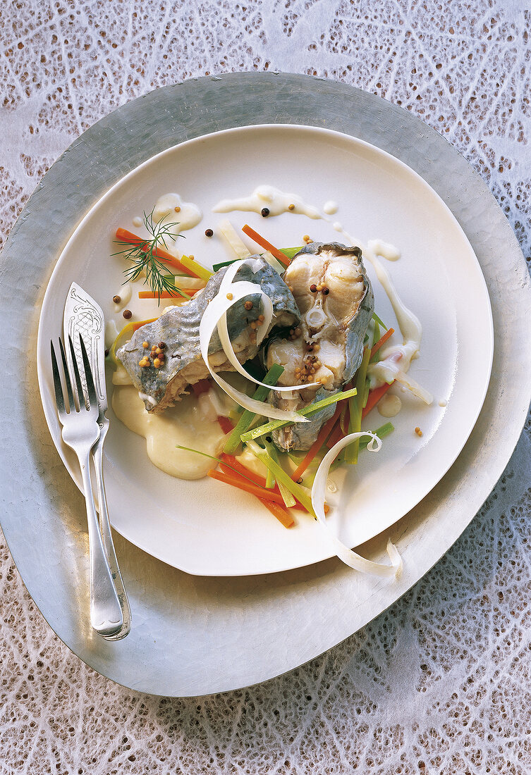 Waller with white sauce and vegetables in serving dish