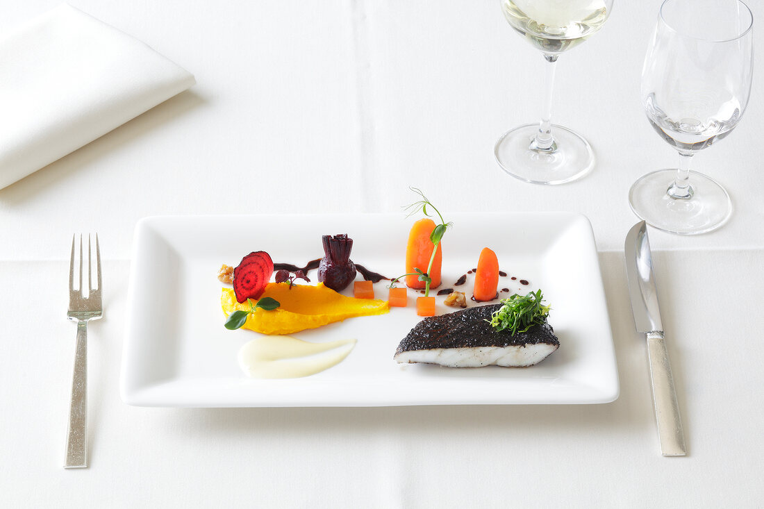 Turbot with trumpet mushroom, carrot and beetroot on serving dish